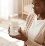 Mum holding Leche Mum portable bottle warmer with baby bottle