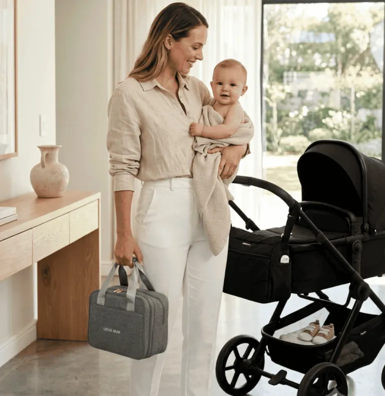 Mum carrying a grey Leche Mum breast pump bag beside a stroller