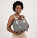Woman holding the grey Leche Mum breast pump bag